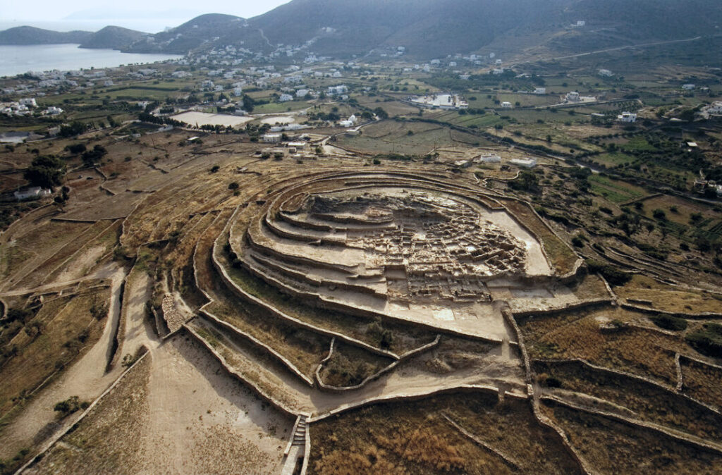 La colina de Skarkos, donde se encuentra el asentamiento del periodo Cicládico Temprano II, domina desde el este la Llanura Baja y el puerto de Ios. Los hallazgos en Skarkos de materias primas y productos elaborados importados a Ios desde otras islas Cícladas, la Grecia continental y otras partes del Egeo indican que el asentamiento desempeñaba un papel activo en el comercio marítimo de la época.
(cyclades.culture.gov.gr)
